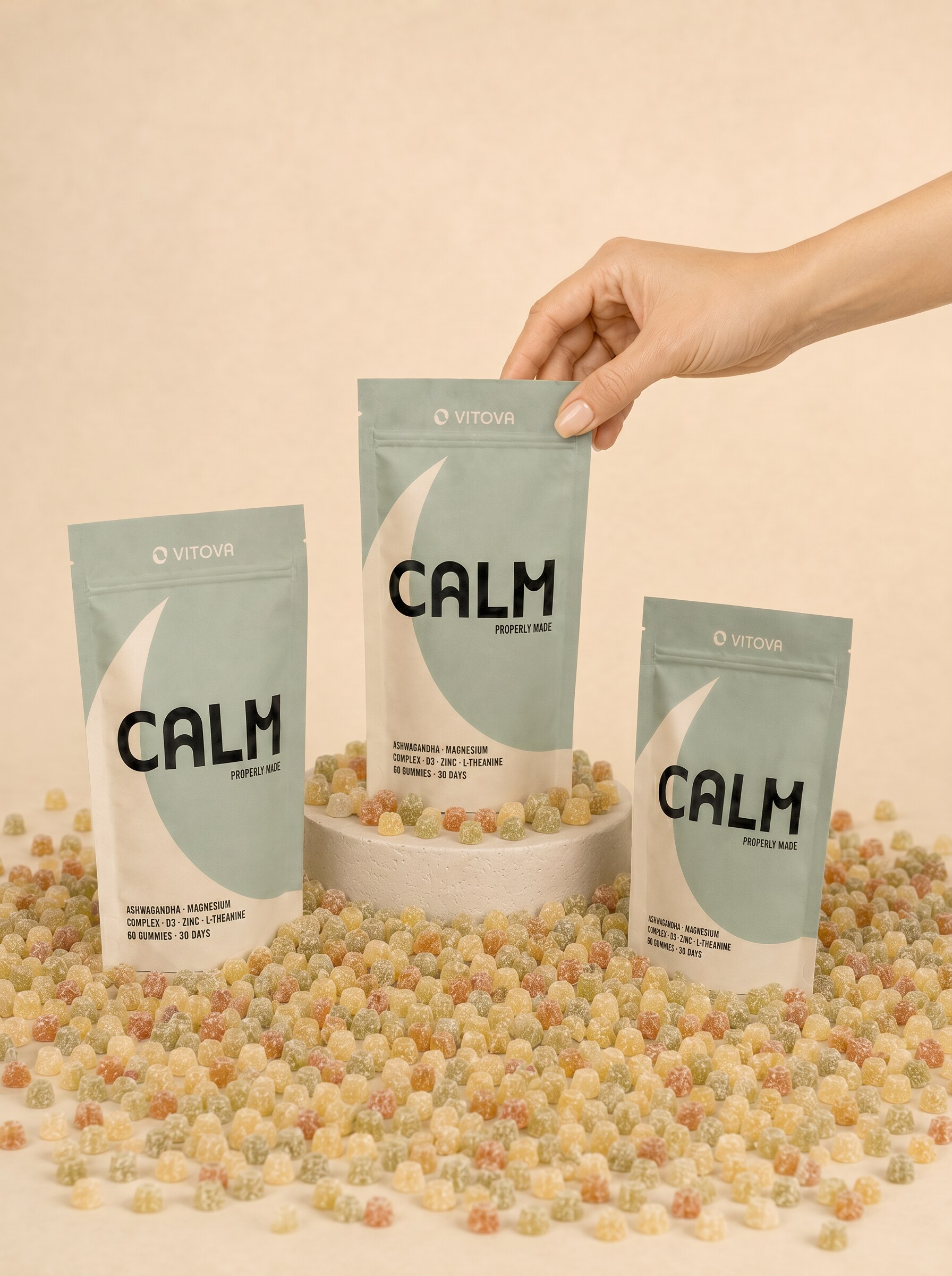 Three Vitova Calm pouches arranged on a pedestal with scattered gummies